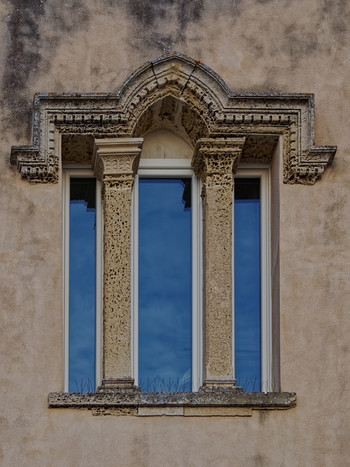 Elegant window portal with a triple window on the old house.