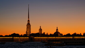 The silhouette of the Peter and Paul Fortress against the background of the sunset sky.