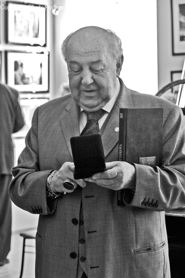 People, Person, Human, Clothing, Overcoat, Suit, Reading